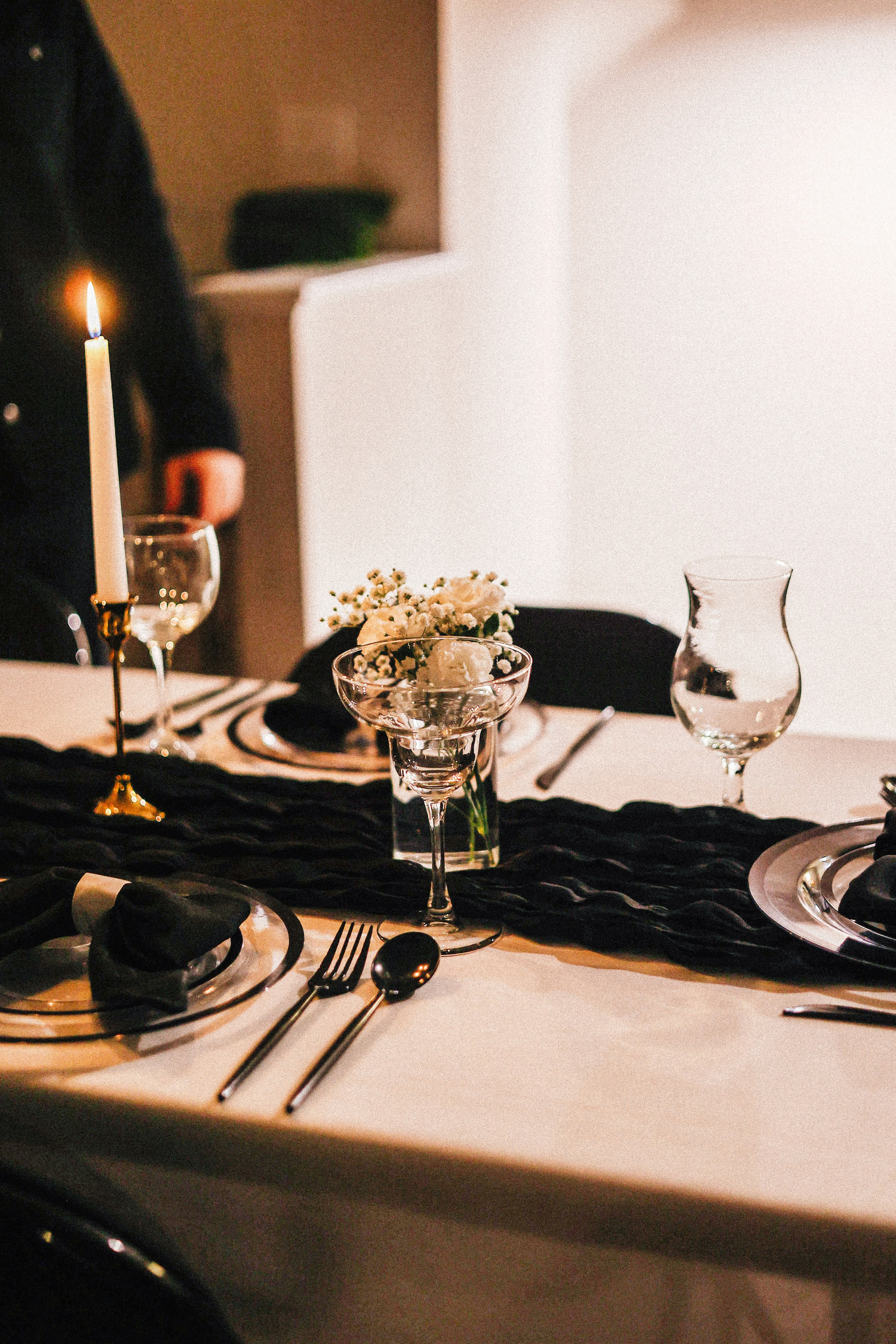 Candlelit dinner table set with wine glasses and elegant place settings, reflecting refined reservation etiquette with Ivory Heritage Club.