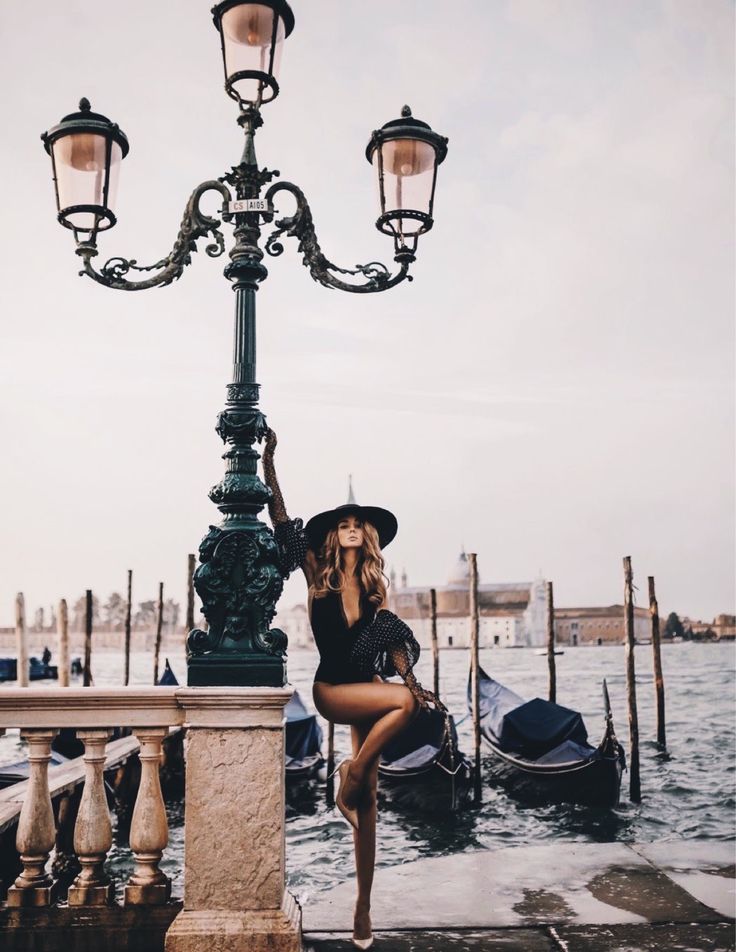 Elegant woman by gondolas in Venice, reflecting refined European travel, presence, and considered lifestyle