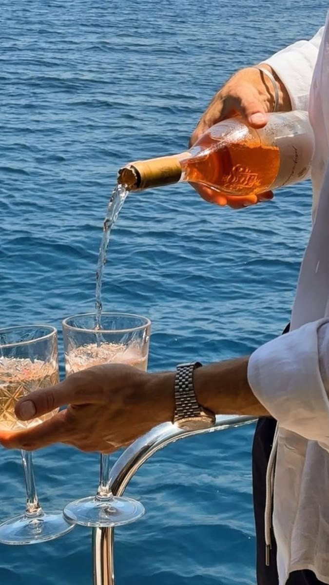 Luxury yacht experience in Ibiza featuring champagne, ocean views, and Mediterranean lifestyle